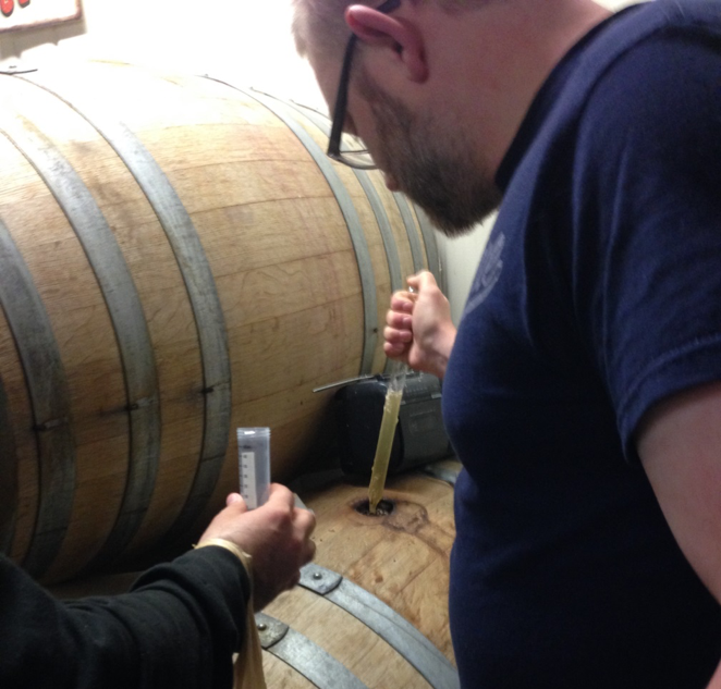 Brewer Cody Morris and UW Seattle scientist Ivan Liachko draw a sample of “Old Warehouse” brew