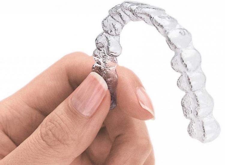 Custom-fitted, clear polymer insert used to straighten teeth.