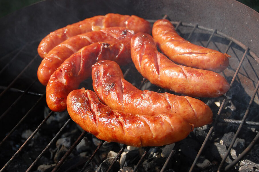 An image of sausages on a grill. Processed meats were listed in 2015 by the International Agency for Research on Cancer as “carcinogenic to humans,” based on population studies that reported slightly increased rates of colorectal cancer in people who consumed the meats. Some speculate that processed meats will soon be added to Proposition 65’s list of chemicals.