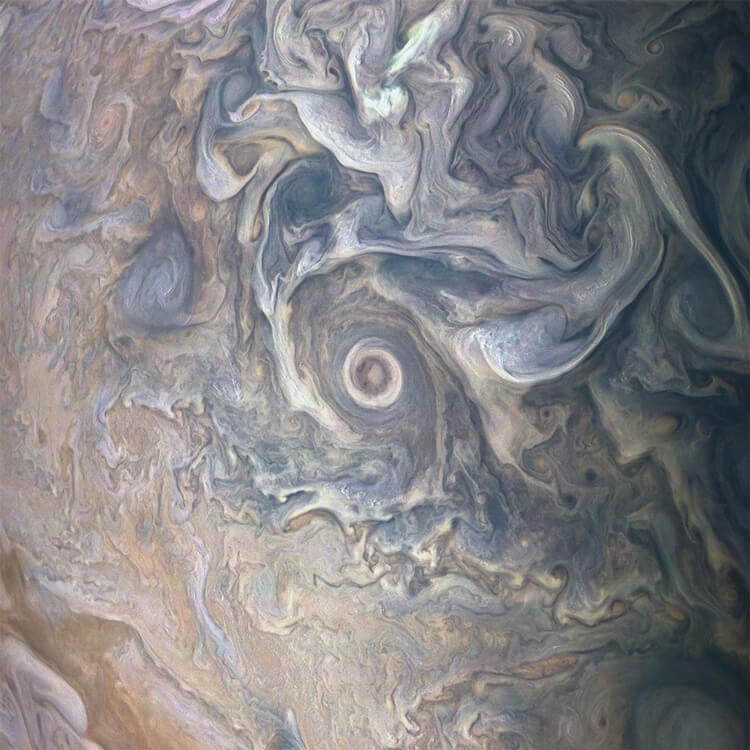 Image shows swirling patterns of clouds in gray, beige and dusty blues.