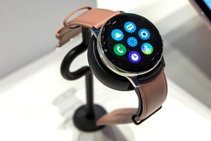 Smartwatch with round display and pink wristband.