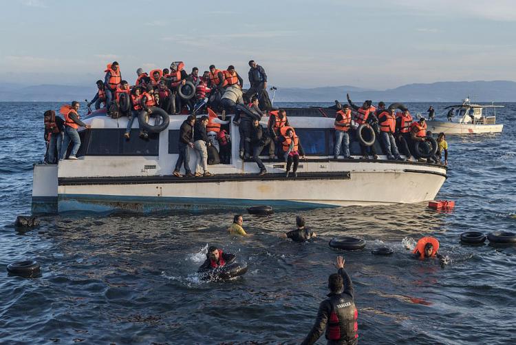 Refugees stand on an overcrowded vessel.