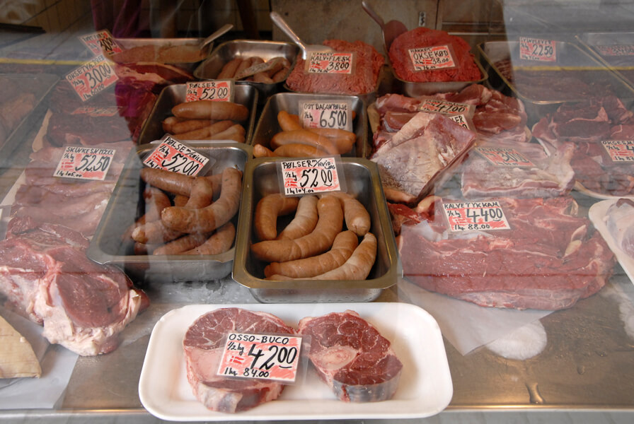 Image shows a variety of meats for sale in the window of a butcher shop in Copenhagen, Denmark. In the discussion over Danishness and accommodating Muslim immigrants, food culture made headlines as people argued over whether nursery schools should serve pork.