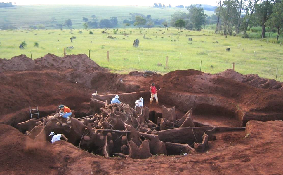 Atta megalopolis Five people work clearing material from a giant excavated underground structure of tunnels and chambers.