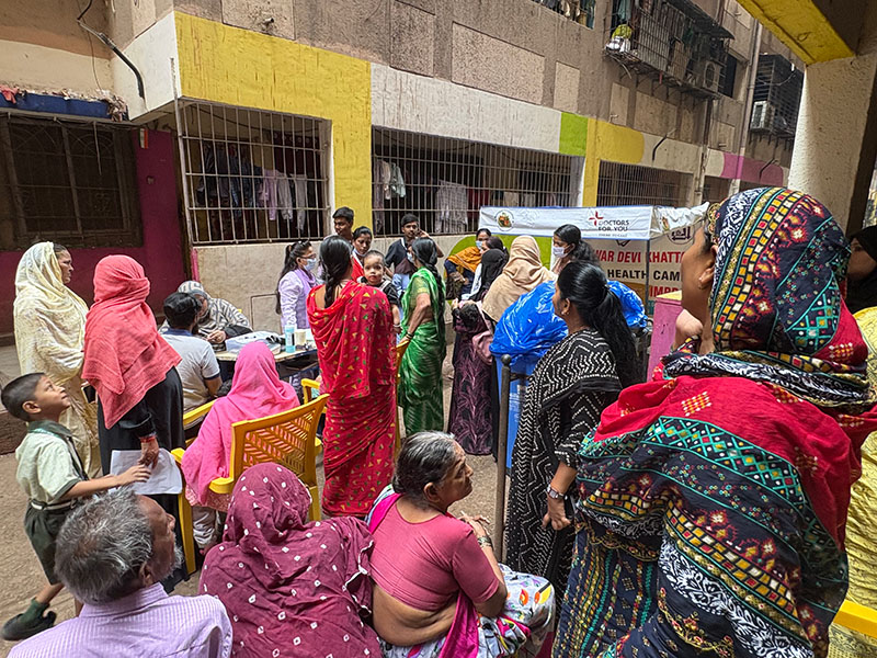 Blood pressure testing A group of women in colorful saris in an alley