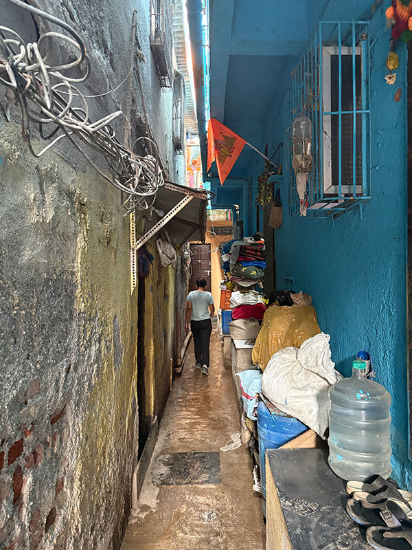 Alley in Dharavi A boy seen from the back walks down a narrow alley between two buildings